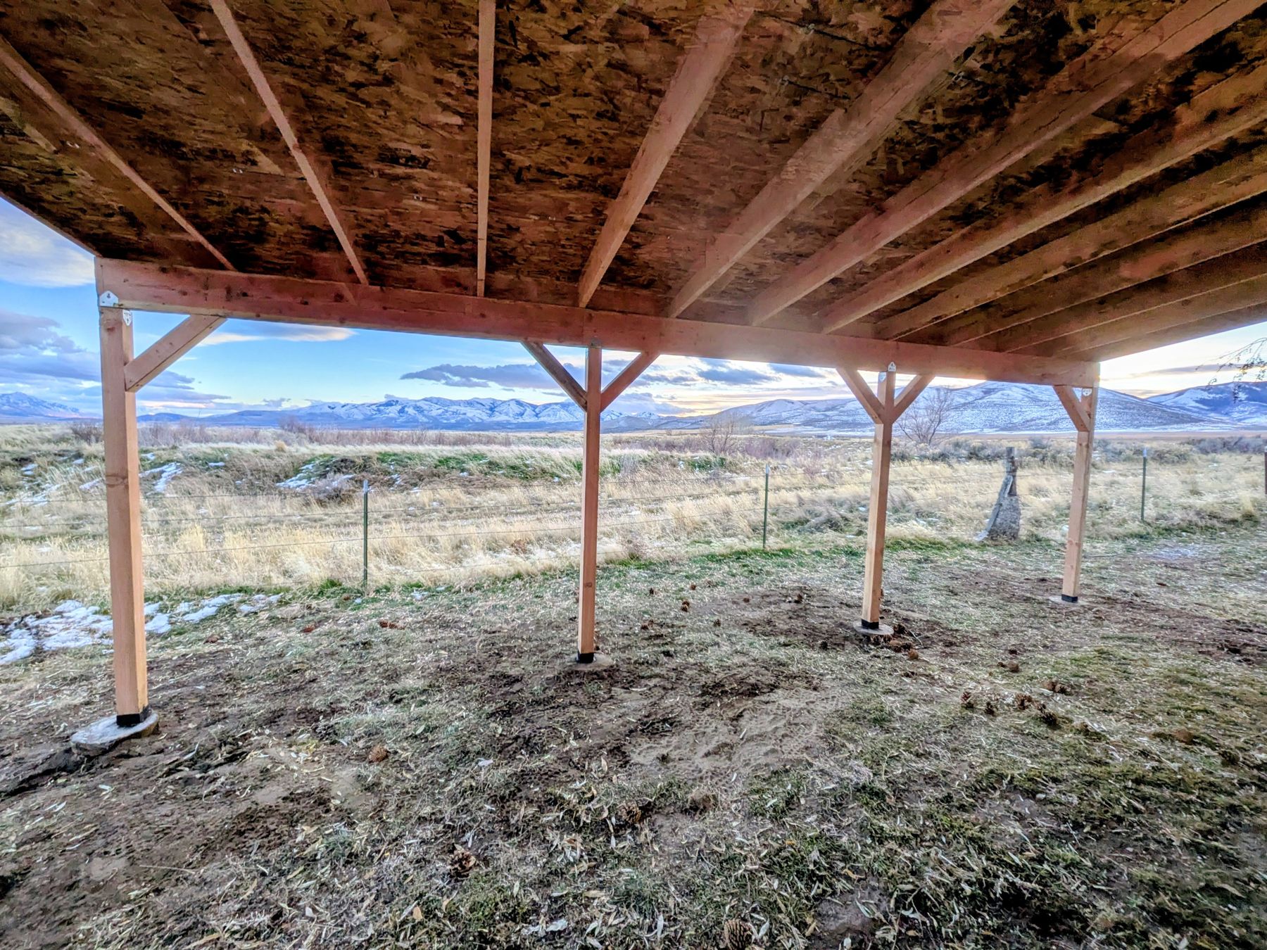 Underside of a covered timber structure open to a valley.