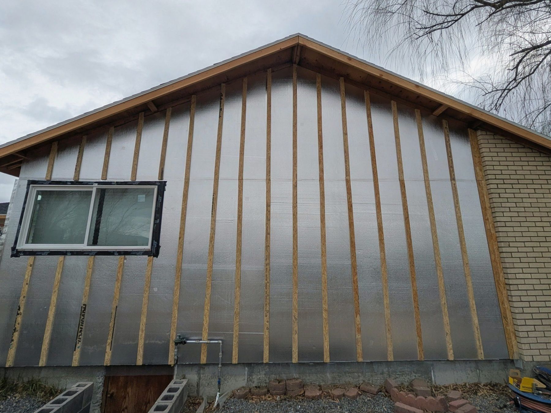 Exterior wall with vertical battens installed around a window.