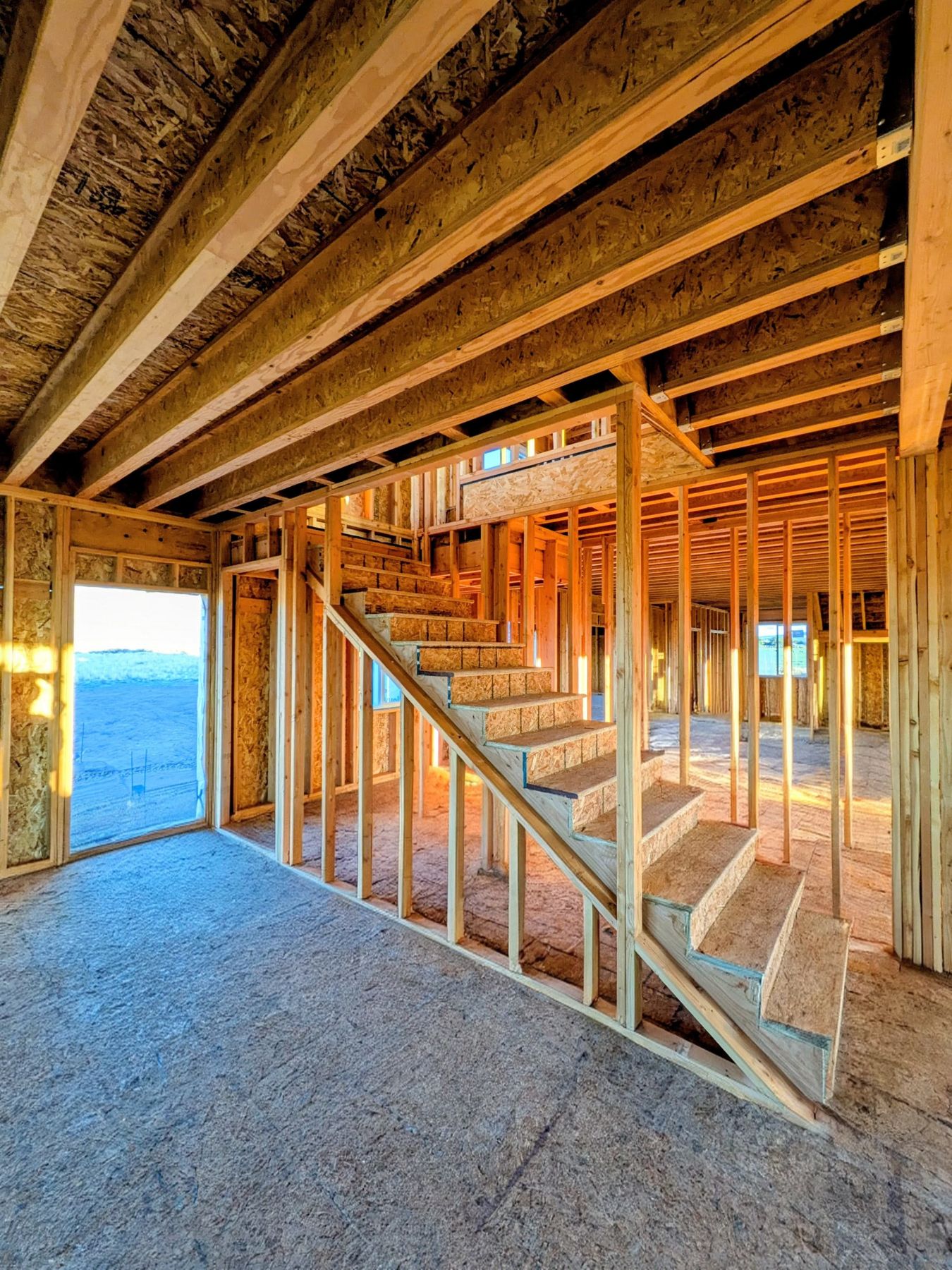 Timber floor framing and a wooden stair during construction.