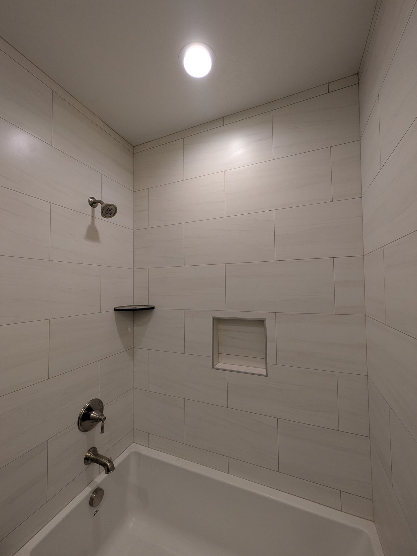 Tiled tub surround with recessed niche.