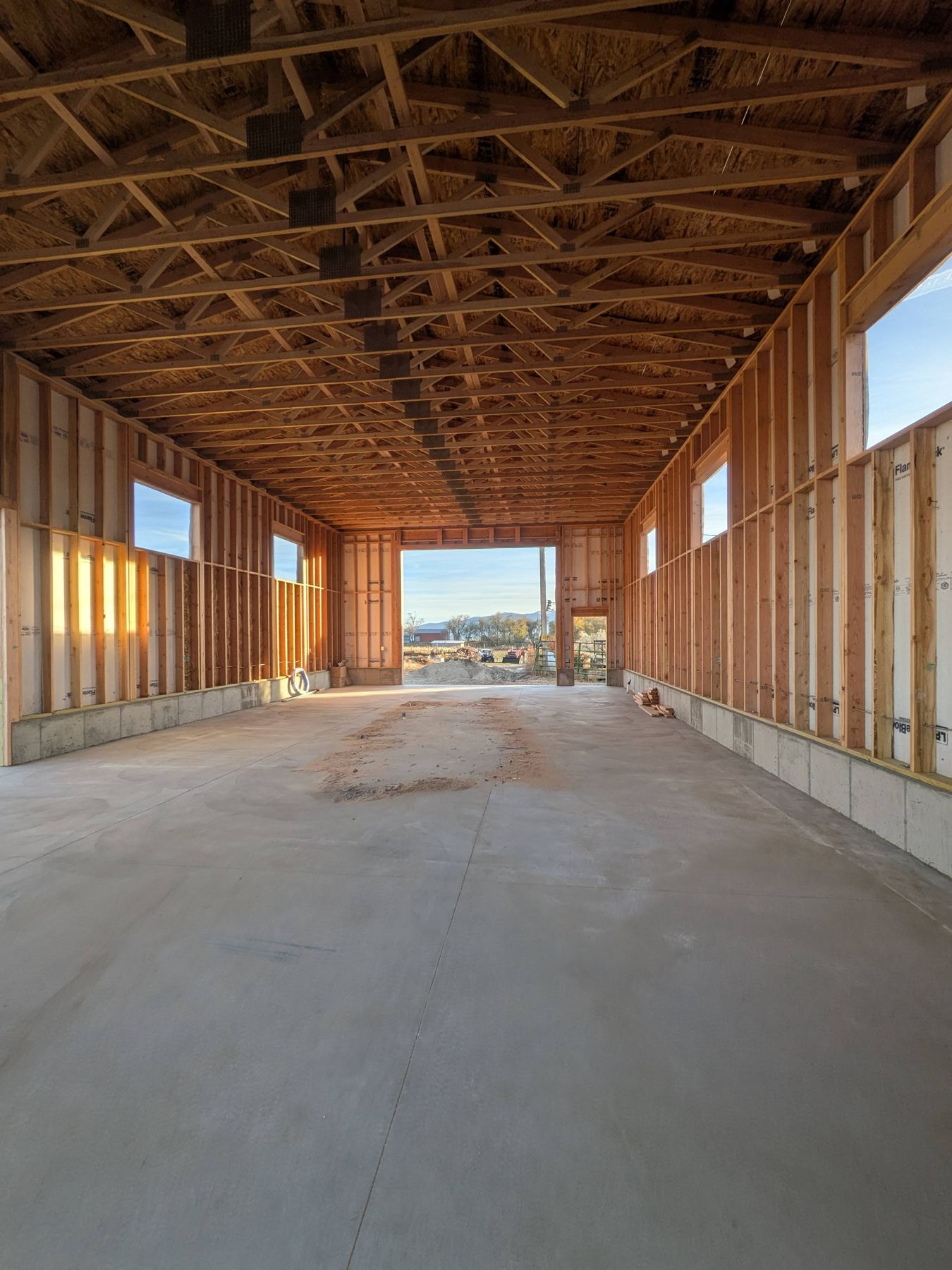 Long framed building with exposed trusses.